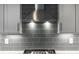 Stainless steel range hood above gas cooktop with gray tile backsplash at 152 Palisade Dr, Rydal, GA 30171