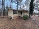 Tan house with black shutters and a tree in front at 6871 Lakeshore Dr, Douglasville, GA 30135