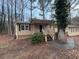 Tan house with black shutters, wooden steps, and landscaping at 6871 Lakeshore Dr, Douglasville, GA 30135