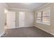 Bright bedroom featuring neutral walls, gray carpeting, and natural light from the window at 2534 Ben Hill Rd, Atlanta, GA 30344