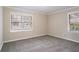 Comfortable bedroom showcasing neutral walls, gray carpeting, and natural light from the two windows at 2534 Ben Hill Rd, Atlanta, GA 30344