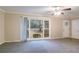 Spacious living room featuring gray carpet, large windows, and a ceiling fan at 2534 Ben Hill Rd, Atlanta, GA 30344