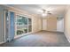 Bright living room boasts gray carpet, sliding glass doors, and a ceiling fan at 2534 Ben Hill Rd, Atlanta, GA 30344