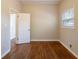 Bedroom with hardwood floors, a window with blinds, an open doorway, and white trim at 3080 Santa Monica Dr, Decatur, GA 30032