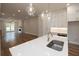 Open concept kitchen with island, white cabinets, and hardwood floors at 620 Goldsmith Ct # 107, Johns Creek, GA 30022