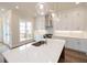 Modern kitchen with white cabinets, quartz countertops, and a kitchen island at 620 Goldsmith Ct # 107, Johns Creek, GA 30022