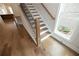 Elegant staircase with hardwood floors and black metal railing at 620 Goldsmith Ct # 107, Johns Creek, GA 30022