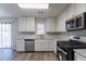 Renovated kitchen with white cabinets, stainless steel appliances, and quartz countertops at 5725 Twain Dr, Ellenwood, GA 30294