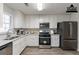 Renovated kitchen with white cabinets, stainless steel appliances, and quartz countertops at 5725 Twain Dr, Ellenwood, GA 30294