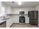 Renovated kitchen with white cabinets, stainless steel appliances, and quartz countertops at 5725 Twain Dr, Ellenwood, GA 30294