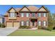 Brick two-story house with a three-car garage and landscaped lawn at 1400 Cresthaven Ln, Lawrenceville, GA 30043