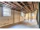 Spacious unfinished basement with exposed ceiling beams, bright windows, and painted brick walls at 1927 Cindy Dr, Decatur, GA 30032