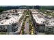 Aerial view of a commercial district featuring buildings with retail and apartments, parking lots, and tree-lined streets at 5320 Memento Trace, Cumming, GA 30040