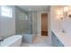 Modern bathroom with a separate tub and shower, double lights, and tile flooring at 5320 Memento Trace, Cumming, GA 30040