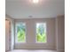 Bedroom with two windows providing ample natural light and views of lush greenery at 5320 Memento Trace, Cumming, GA 30040