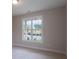 Well-lit bedroom with a large window showcasing outdoor views and plush carpeting at 5320 Memento Trace, Cumming, GA 30040