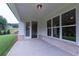 Covered patio featuring brick accents, ample sunlight, and access to the home's interior through glass doors at 5320 Memento Trace, Cumming, GA 30040