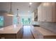 Modern kitchen with gray lower cabinets, white upper cabinets, a gas cooktop, and a view to the breakfast nook at 5320 Memento Trace, Cumming, GA 30040