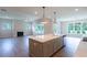Open-concept kitchen with island, stainless appliances, and hardwood floors lead to the living room with fireplace at 5320 Memento Trace, Cumming, GA 30040