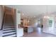 Open-concept kitchen with staircase, island, and stainless appliances, and hardwood floors lead to the living room at 5320 Memento Trace, Cumming, GA 30040