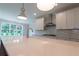 Bright kitchen with a stone countertop island and white cabinets, backsplash, and lighting features at 5320 Memento Trace, Cumming, GA 30040