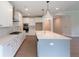 Bright, modern kitchen featuring white cabinets, stainless steel appliances, and a large center island with a sink at 5320 Memento Trace, Cumming, GA 30040