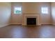 Cozy living room with hardwood floors and fireplace, flanked by two windows and bright trim work at 5320 Memento Trace, Cumming, GA 30040