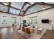Bright living area featuring vaulted ceilings, wood beams, and a seating area bathed in natural light at 5320 Memento Trace, Cumming, GA 30040