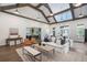 Beautiful living area featuring vaulted ceilings, wood beams, and a seating area with natural light at 5320 Memento Trace, Cumming, GA 30040