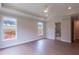 Open main bedroom with hardwood floors, a tray ceiling, and an ensuite bathroom at 5320 Memento Trace, Cumming, GA 30040