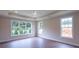 Open and bright main bedroom with hardwood floors, a tray ceiling, and a fan at 5320 Memento Trace, Cumming, GA 30040