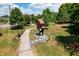 Park statue showing a Personal carrying a large rectangular burden, set within a green park landscape on a sunny day at 5320 Memento Trace, Cumming, GA 30040