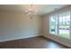 A versatile room with hardwood floors, a modern light fixture, and a large window for abundant natural light at 5320 Memento Trace, Cumming, GA 30040