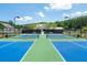 Bright, outdoor tennis courts with blue and green surface for active community lifestyle at 5320 Memento Trace, Cumming, GA 30040