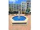 Town square fountain with blue water, stone accents, and surrounding shops and restaurants with outdoor seating at 5320 Memento Trace, Cumming, GA 30040
