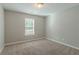 Spacious carpeted bedroom with window and neutral walls at 7133 Pineview Sw Dr, Covington, GA 30014