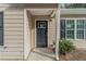 Front door entry with a dark gray door and white trim at 7133 Pineview Sw Dr, Covington, GA 30014
