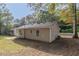 Tan house exterior with backyard and partial view of surrounding trees at 7133 Pineview Sw Dr, Covington, GA 30014