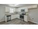 Modern kitchen with white cabinets, granite countertops, and stainless steel appliances at 7133 Pineview Sw Dr, Covington, GA 30014