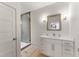 Modern bathroom with white vanity, gray tile shower, and light wood floors at 1782 Patrick Rd, Dacula, GA 30019