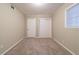 Bedroom with neutral walls and plush carpet, features bright window and closet at 3401 Tulip Dr, Decatur, GA 30032