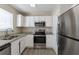 Modern kitchen featuring stainless steel appliances, granite countertops, and white cabinets at 128 Prity Ct, Mcdonough, GA 30253