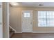 Living room featuring a stairwell and front door with large windows for natural light at 128 Prity Ct, Mcdonough, GA 30253