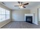 Spacious living room featuring a decorative ceiling fan, fireplace, and large windows for natural light at 128 Prity Ct, Mcdonough, GA 30253