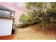 Landscaped backyard with mature trees and a sloped terrain at 4126 Mcbride Dr, Powder Springs, GA 30127
