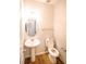 Clean bathroom with pedestal sink, toilet and oval mirror at 4126 Mcbride Dr, Powder Springs, GA 30127