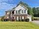 Two-story brick home with gray siding, landscaped lawn, and attached garage at 4126 Mcbride Dr, Powder Springs, GA 30127