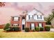 Two-story brick home with gray siding, landscaped lawn, and attached garage at 4126 Mcbride Dr, Powder Springs, GA 30127