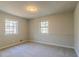 Simple bedroom with carpet, neutral walls and two windows at 8652 Embrey Dr, Jonesboro, GA 30236