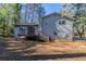 Gray house exterior with wooden deck and stairs in wooded setting at 8652 Embrey Dr, Jonesboro, GA 30236